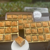 Traditional Baklava Hostess Bitty Baks - Delivered Fresh! Relish the classic taste of our bite-sized baklava. Crafted with buttered phyllo layers, sprinkled with premium nuts, and drizzled with a delicate syrup. Perfect for sharing or indulging alone. Experience the gold standard of baklava, now shipped straight to your door.